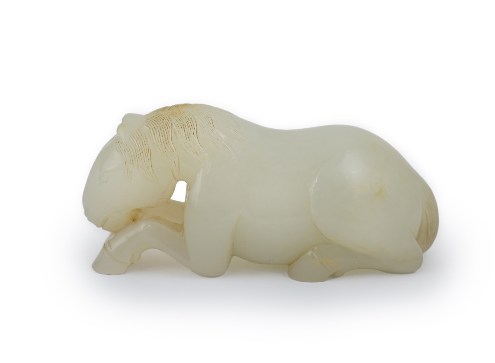A Chinese white jade figure of a recumbent horse